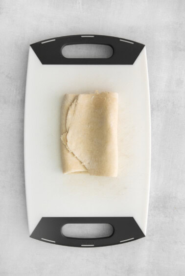 a piece of dough on a cutting board.