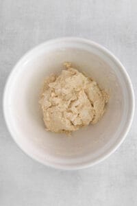 a white bowl with dough in it.