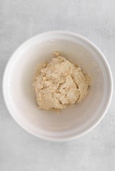 a white bowl with dough in it.