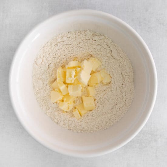 a white bowl with flour and butter in it.