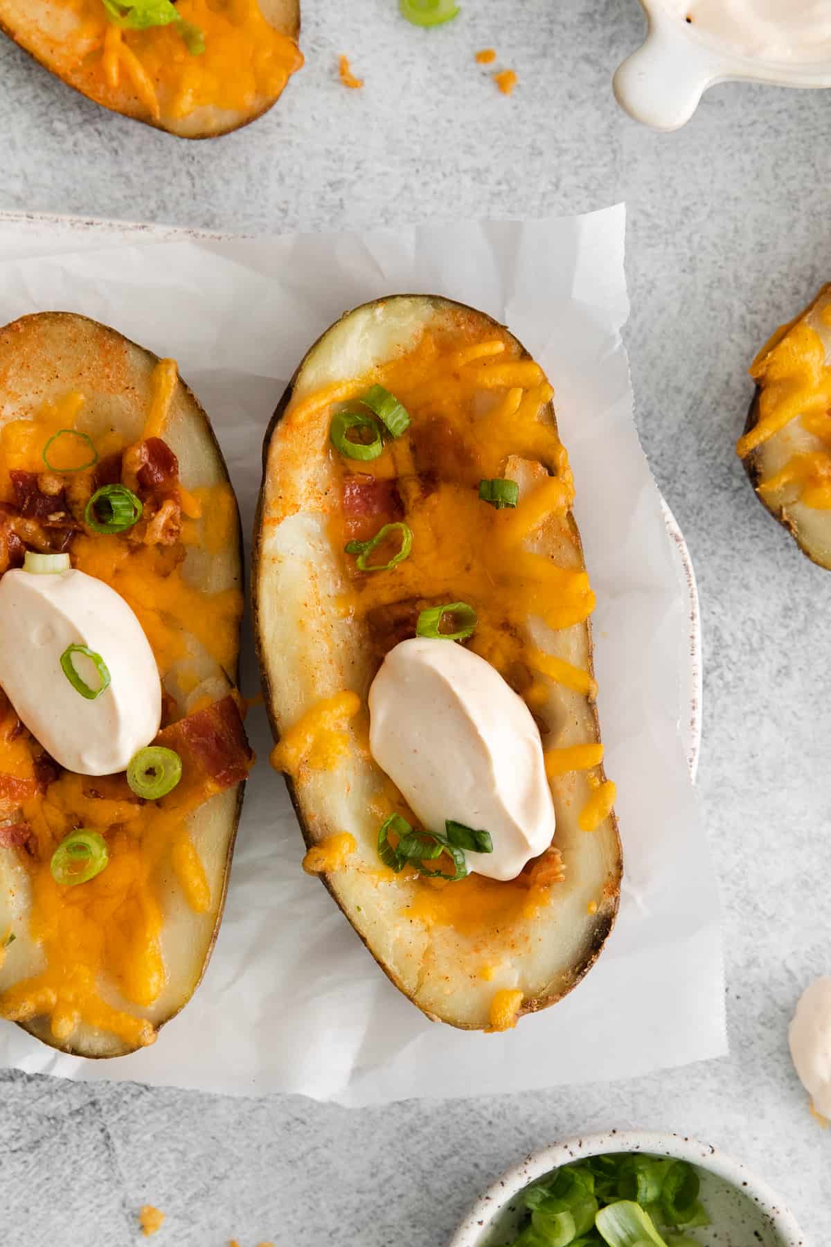 Cheesy potato skins topped with cheese, bacon, and green onions. 