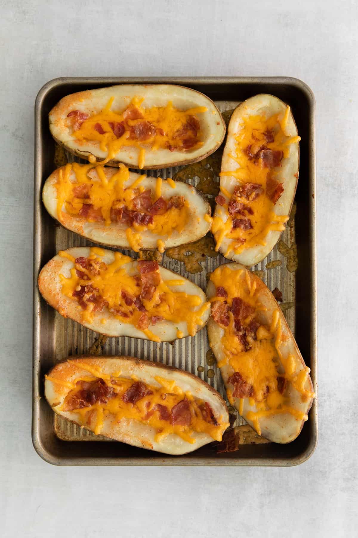 Cheesy potato skins on a baking tray. 
