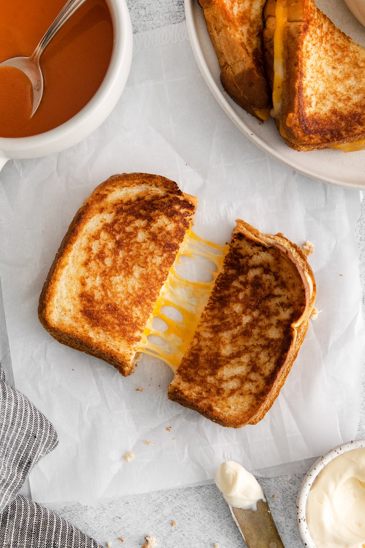 Grilled cheese with mayo cut in half.