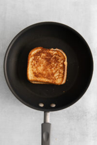 a piece of toasted bread in a frying pan.