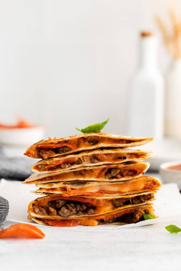 Pizza quesadilla stacked on a plate.