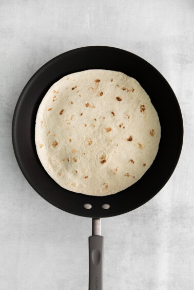 A tortilla in a skillet.