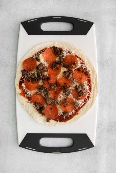 A tortilla with sauce, cheese, and protein.