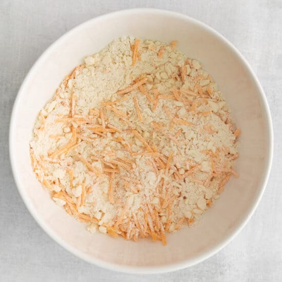 shredded carrots in a white bowl.