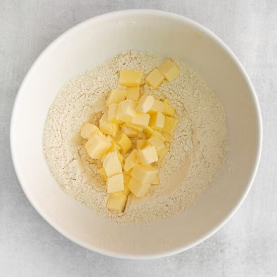 a bowl of flour and butter in a white bowl.