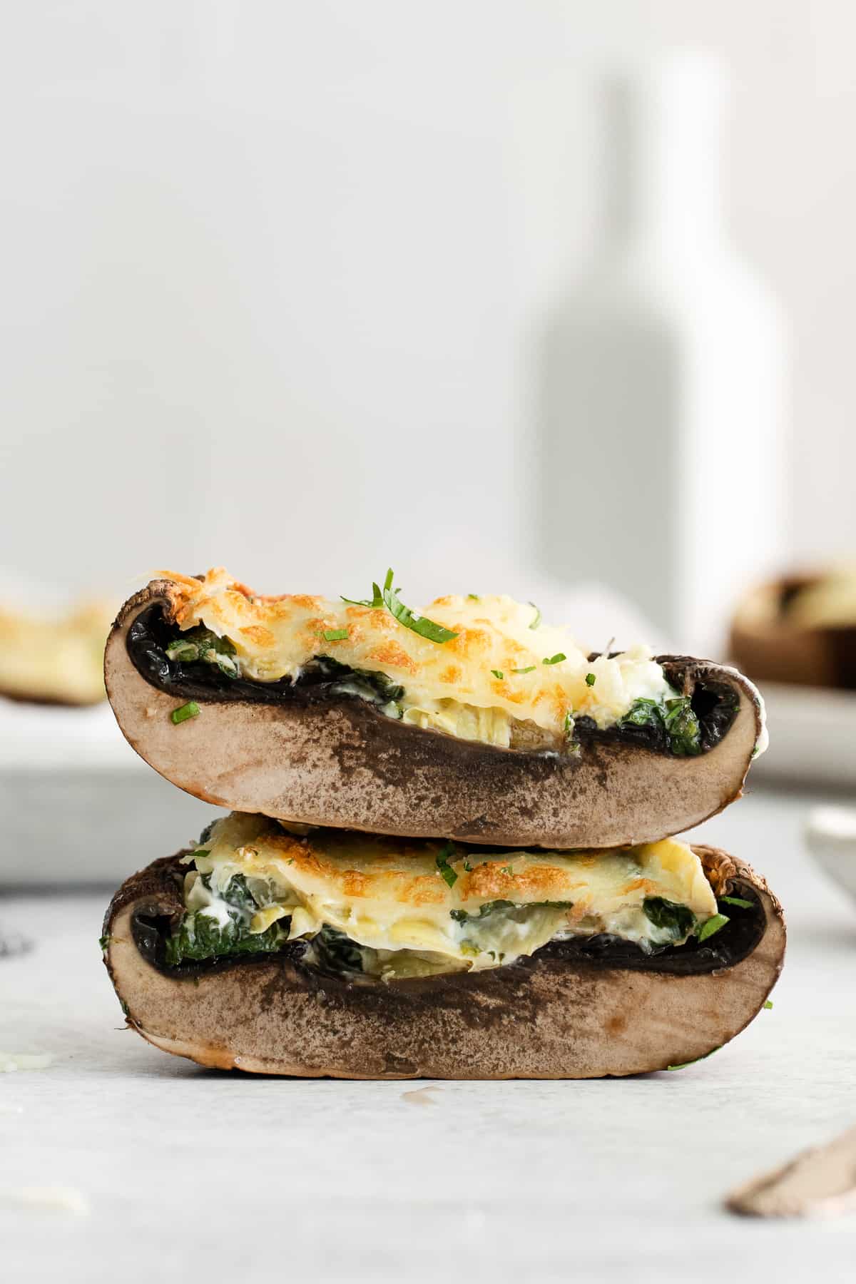 Stacked stuffed mushrooms on a counter top.