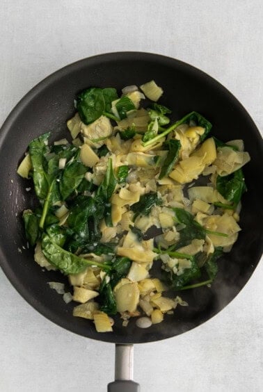 Spinach and artichoke in a skillet.