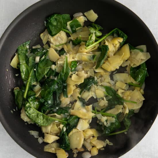 Spinach and artichoke in a skillet.