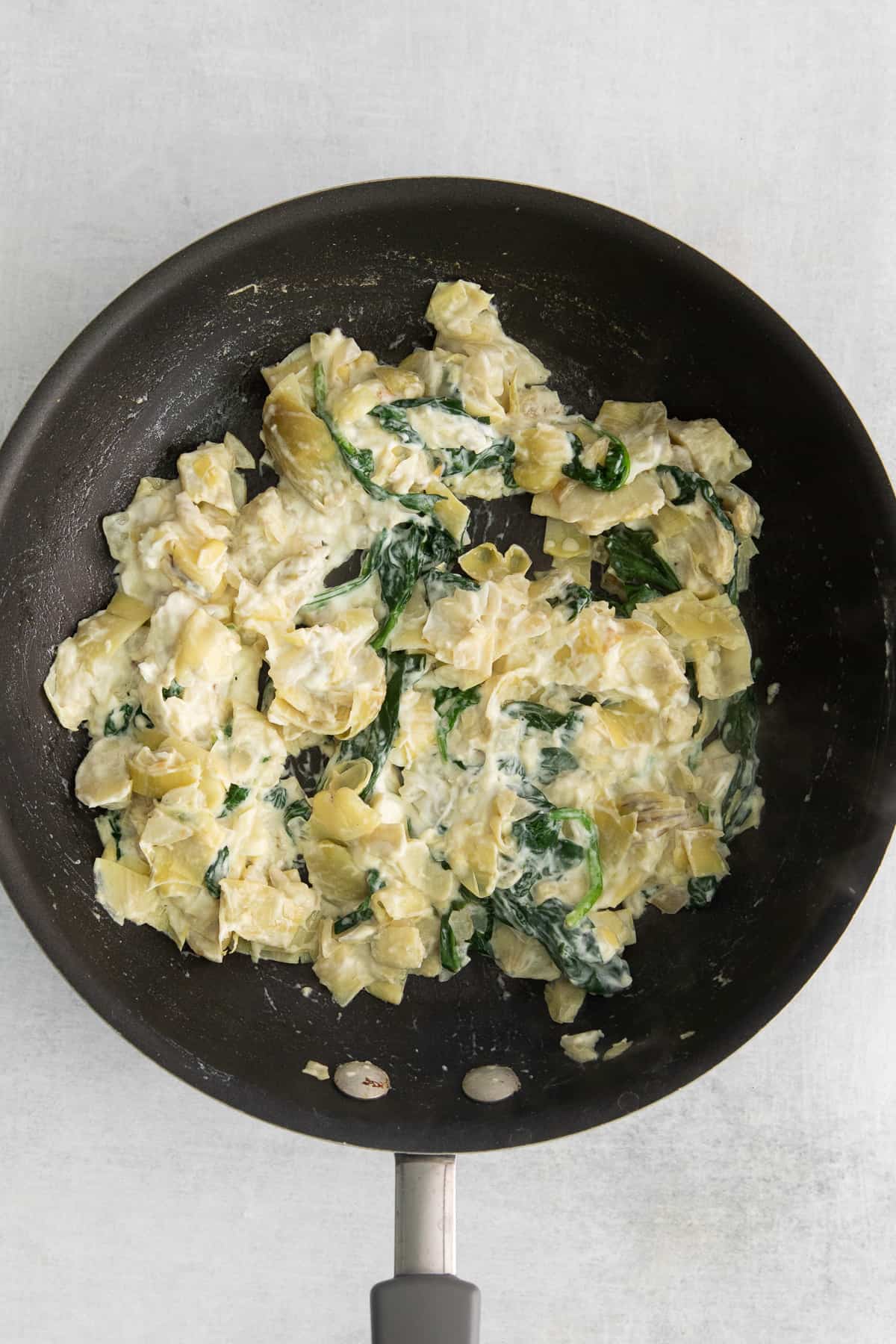 Spinach artichoke dip in a skillet.