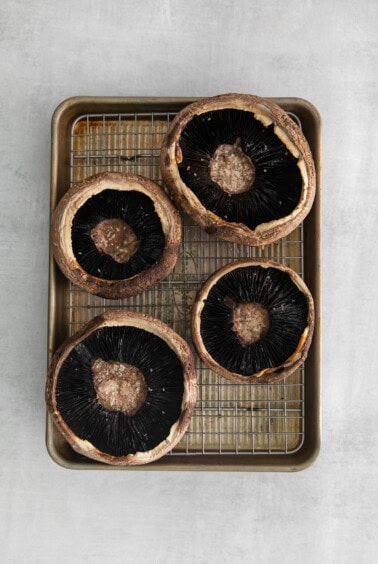Hallowed out mushrooms on a baking sheet.