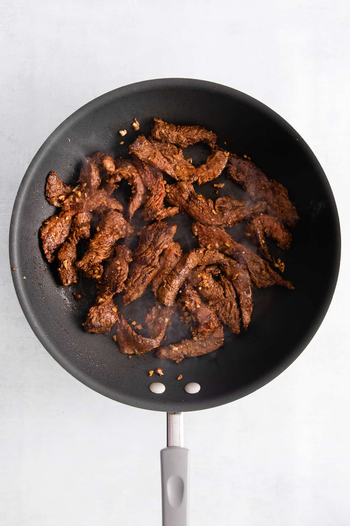 Pan frying steak in a skillet.