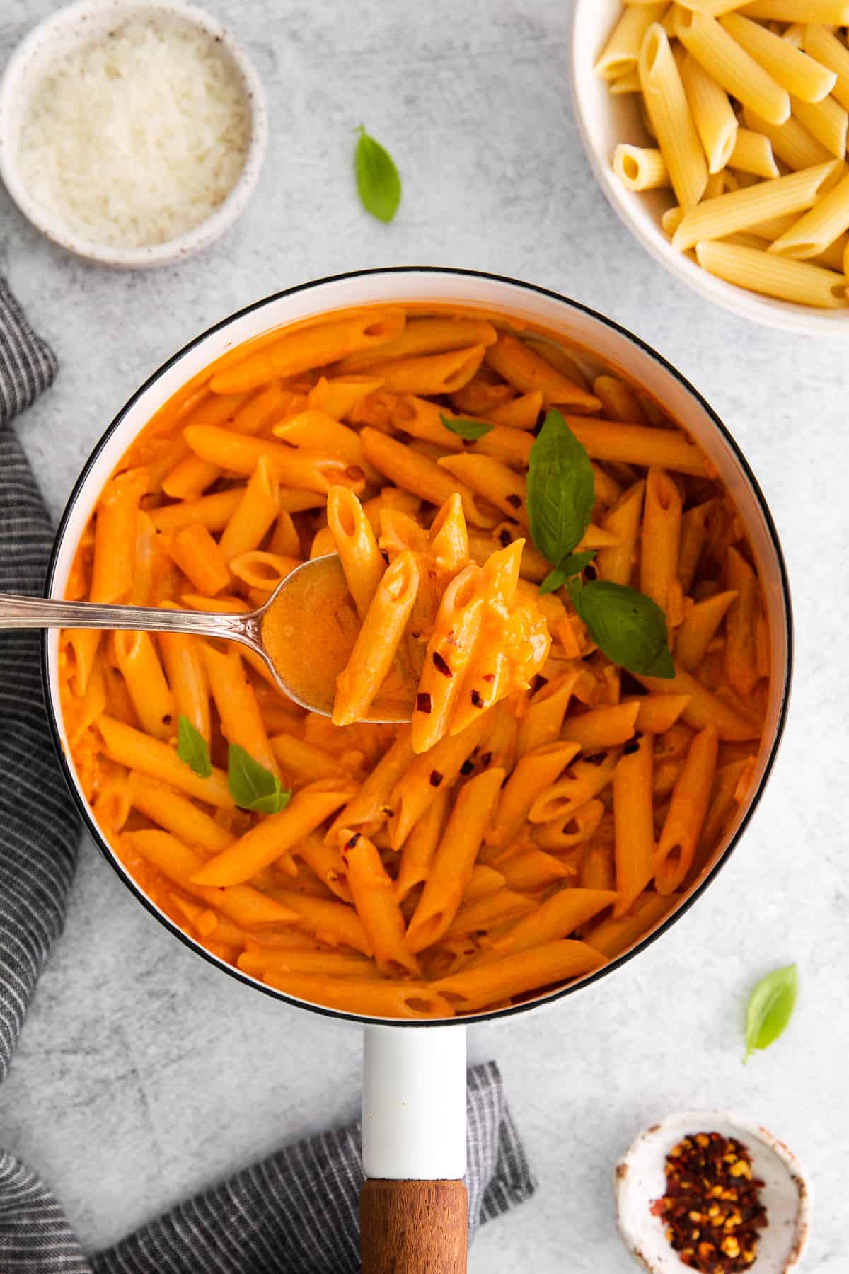 penne a la vodka with a spoon in pot.