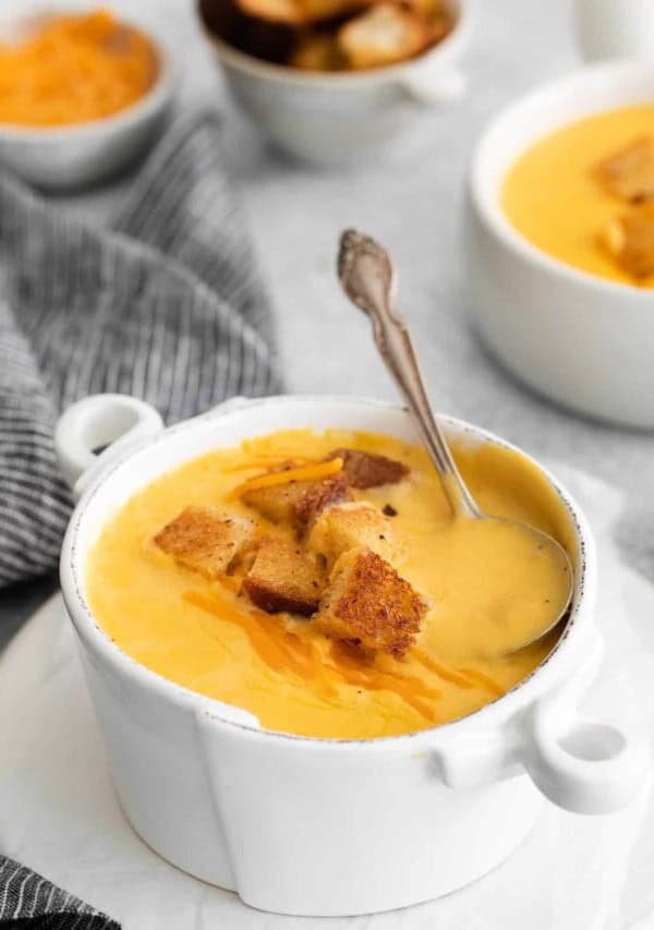 a bowl of Cheddar Cheese Soup with a spoon