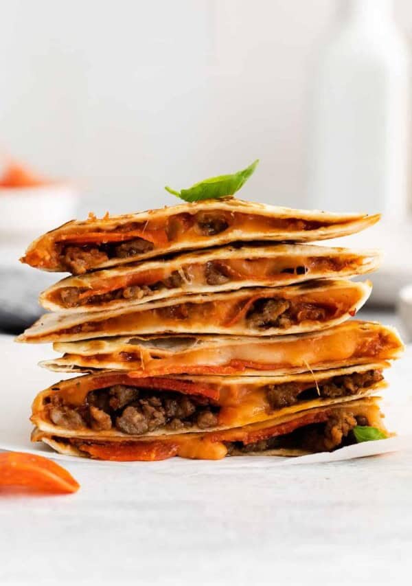 Pizza quesadilla stacked on a plate.