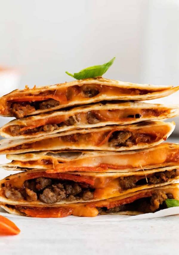 A pizza quesadilla stacked on a plate.