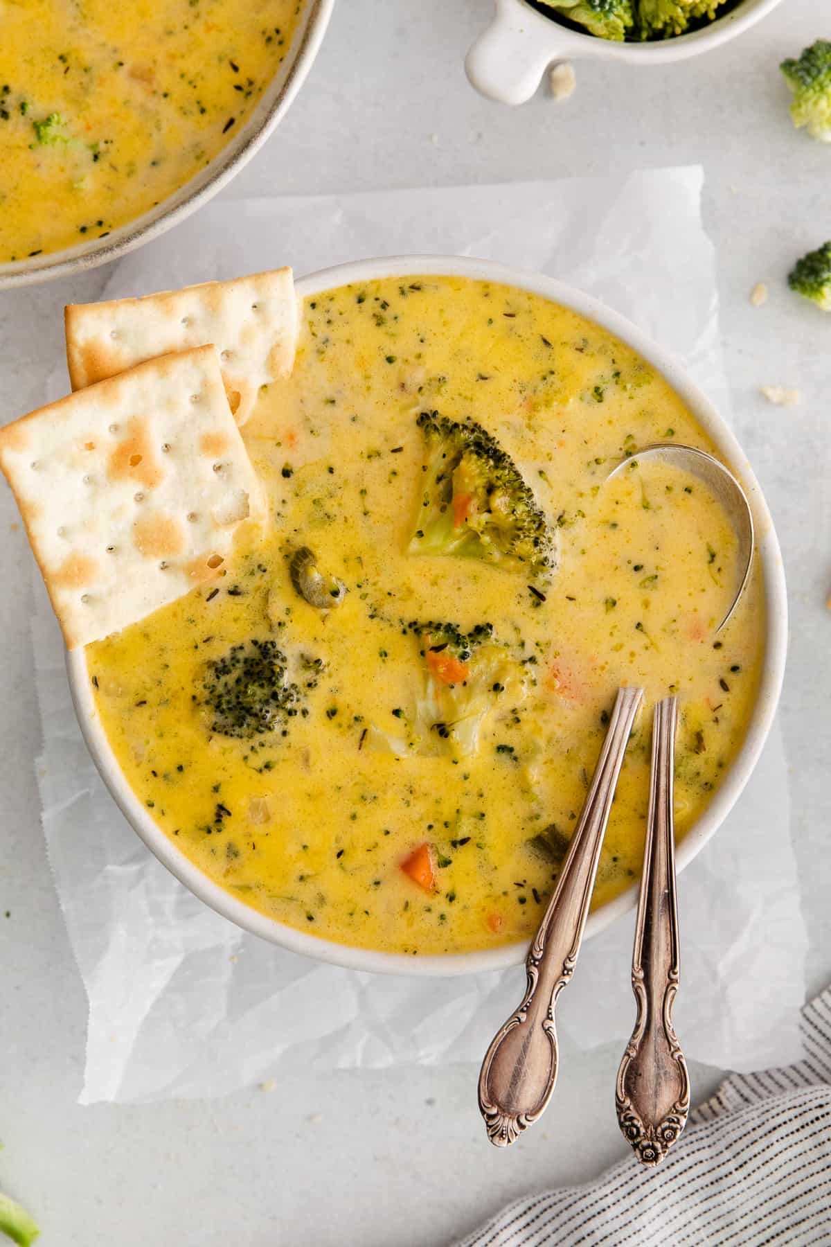 Broccoli potato cheese soup with crackers on the side.