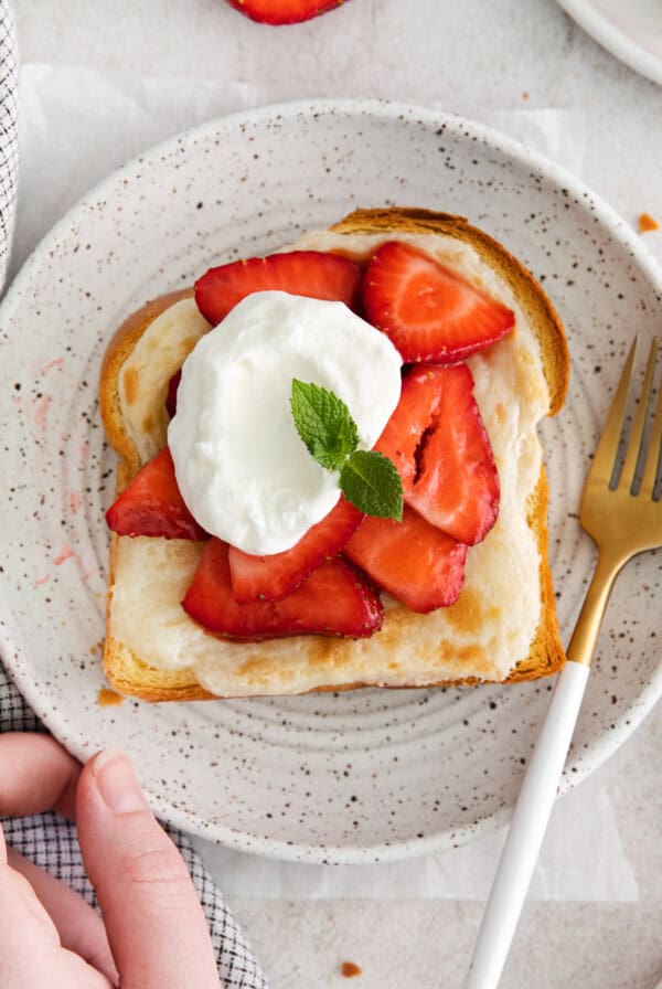 strawberry cheesecake French toast topped with whipped cream and strawberries.