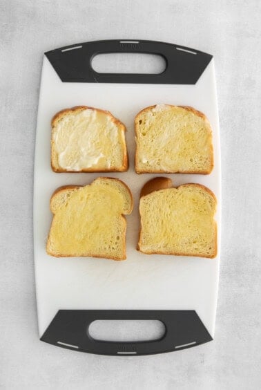 four slices of bread on a white cutting board.