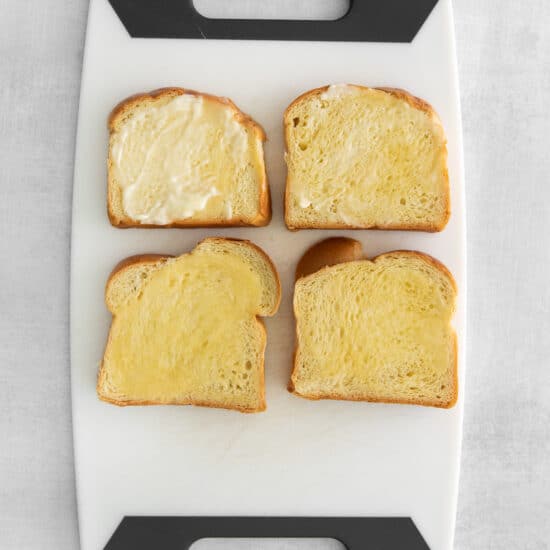 four slices of bread on a white cutting board.
