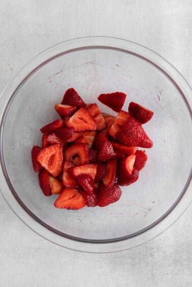 sliced strawberries in a glass bowl.