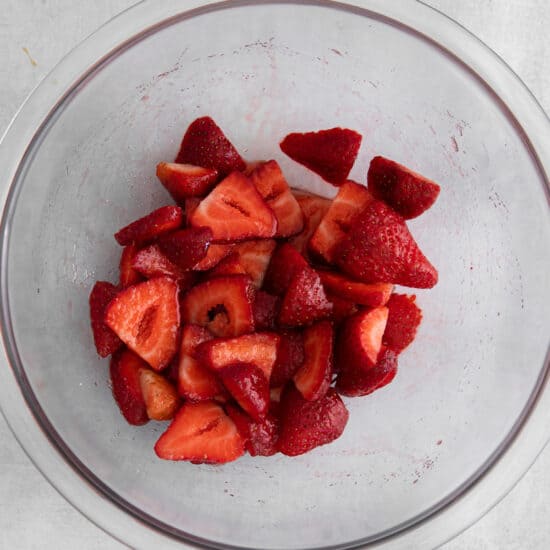 sliced strawberries in a glass bowl.