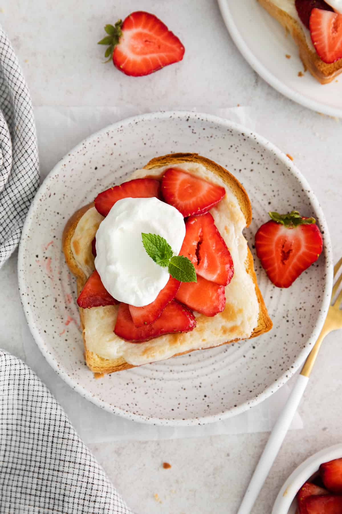 Strawberry cheesecake french toast on a plate topped with whipped cream and strawberries.
