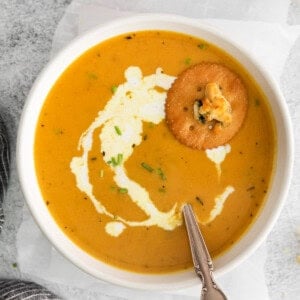 pumpkin soup in bowl with ritz cracker.