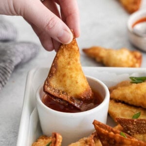 dipping rangoon in sauce.