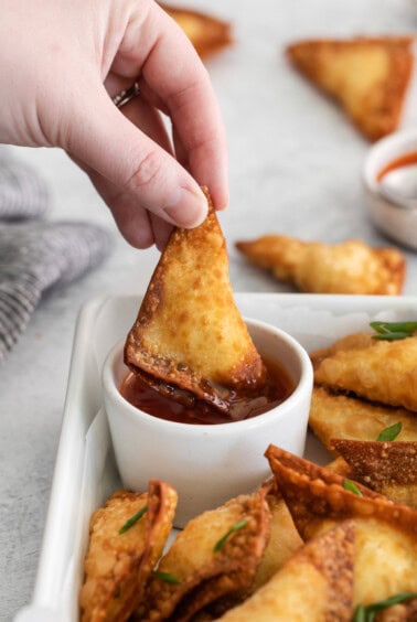 dipping rangoon in sauce.