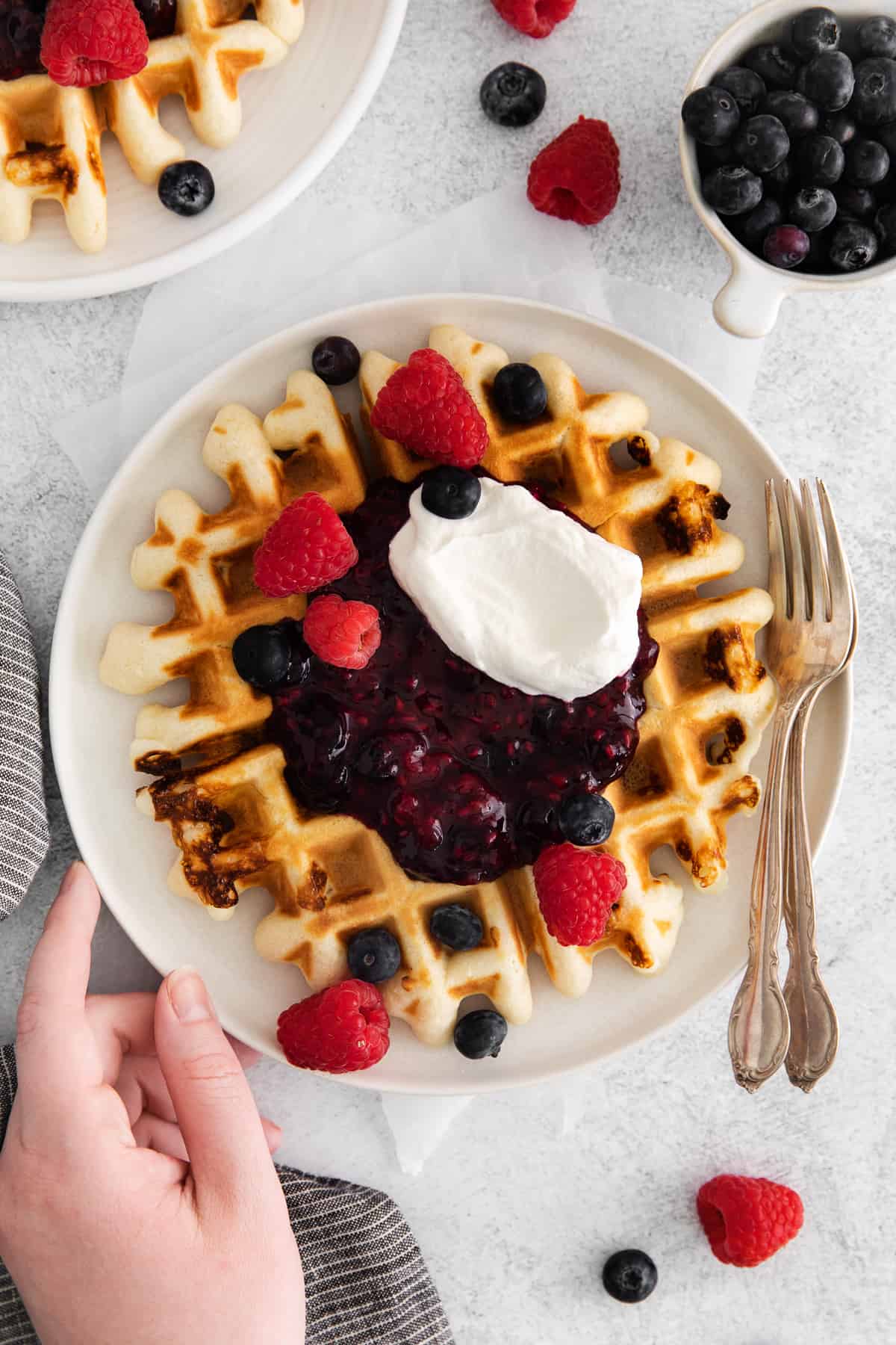 waffle with berry compote and berries on top.