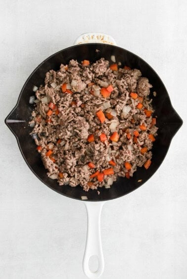 a skillet filled with ground beef and carrots.