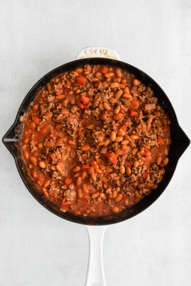 a skillet filled with beans and meat.