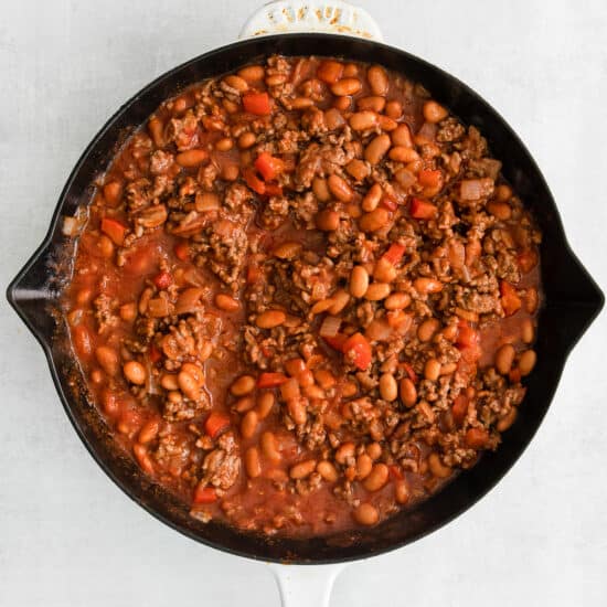 a skillet filled with beans and meat.