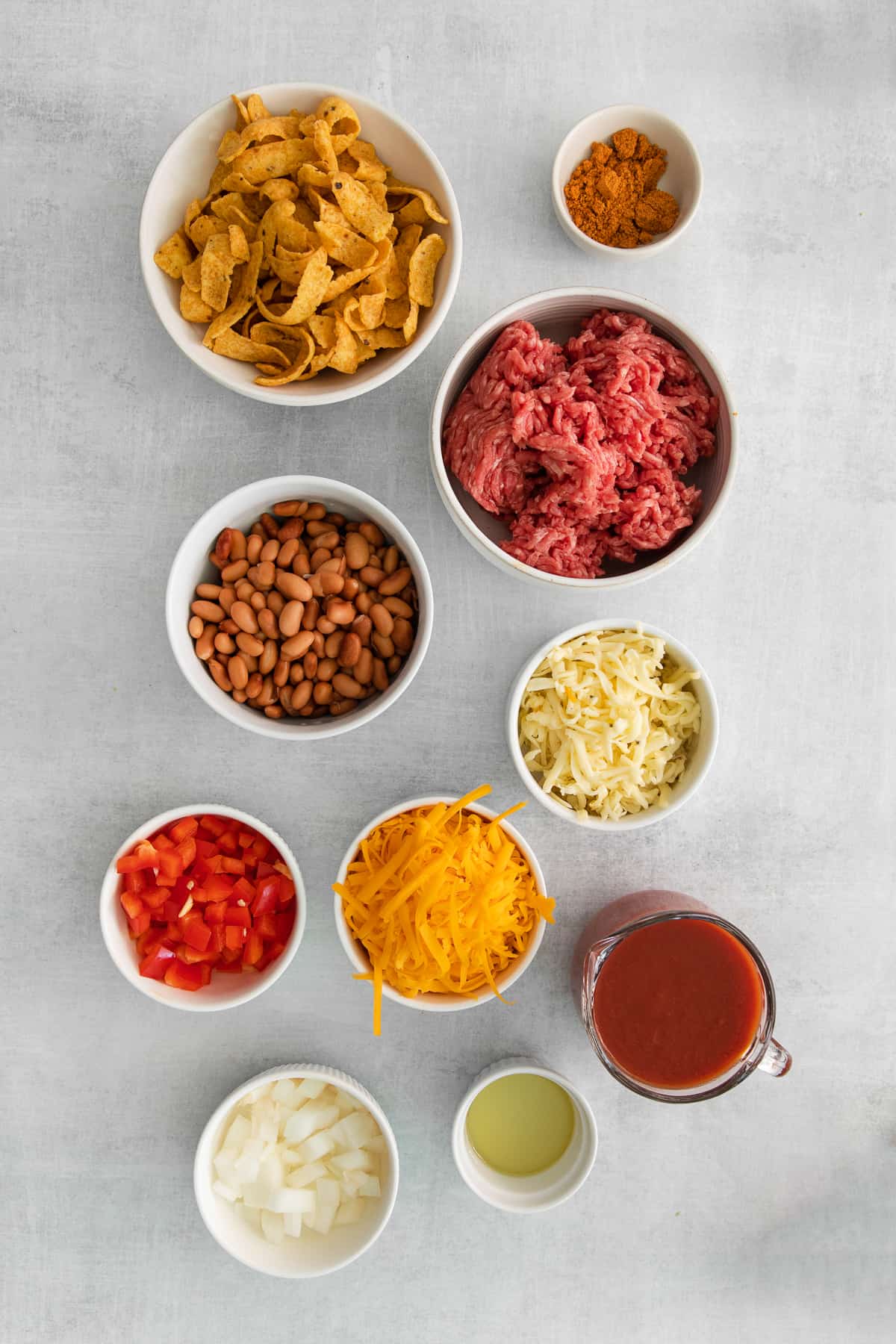 Ingredients for a cheesy frito taco skillet in bowls.