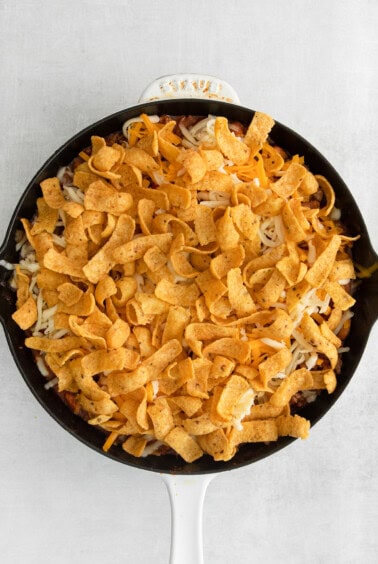 a skillet filled with nachos and cheese.