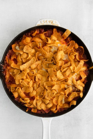 a skillet filled with nachos and tortilla chips.