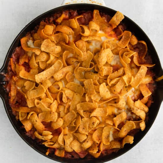 a skillet filled with nachos and tortilla chips.