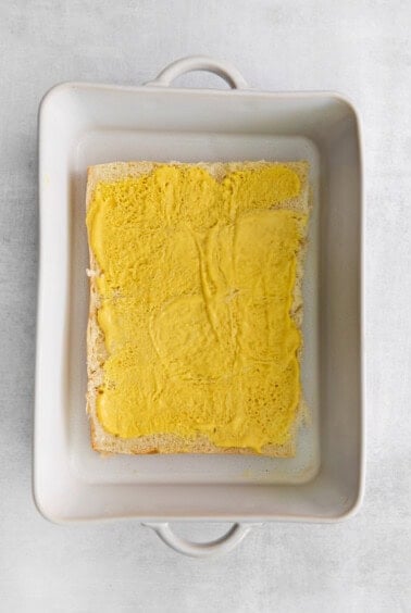 a square of yellow bread in a square dish.