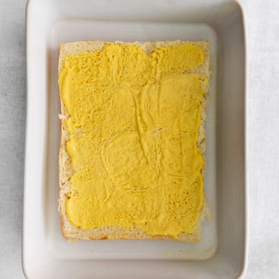 a square of yellow bread in a square dish.