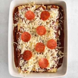 pepperoni and cheese on top of lasagna roll ups.