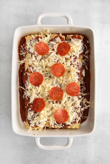 pepperoni and cheese on top of lasagna roll ups.
