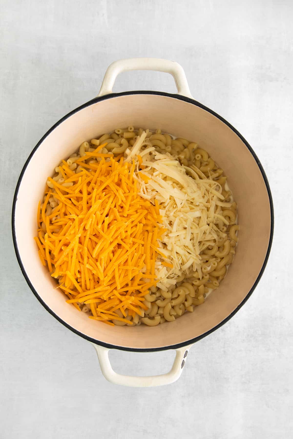 shredded cheese and noodles in Dutch oven.
