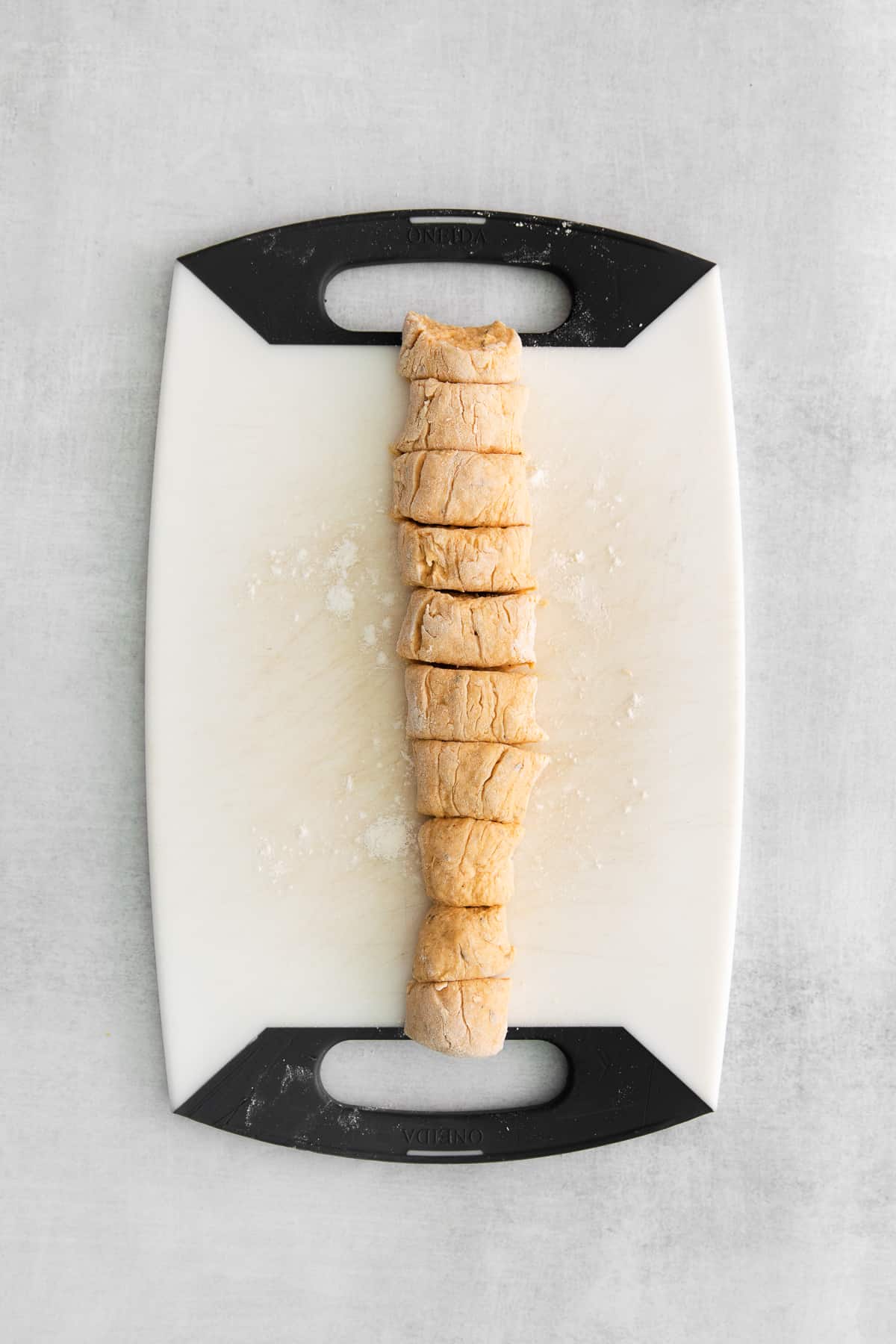 gnocchi dough sliced on cutting board.