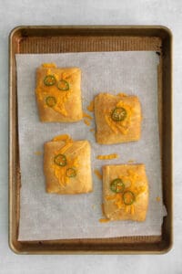 cheesy jalapeno poppers on a baking sheet.