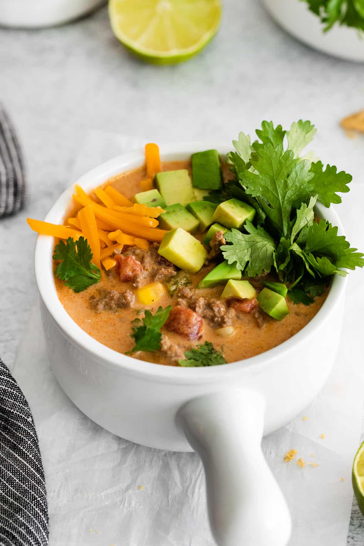 soup in bowl with cheddar cheese, avocado, and cilantro.