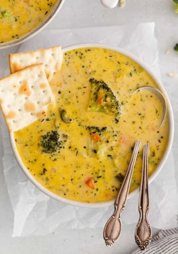 Broccoli potato cheese soup with crackers on the side.